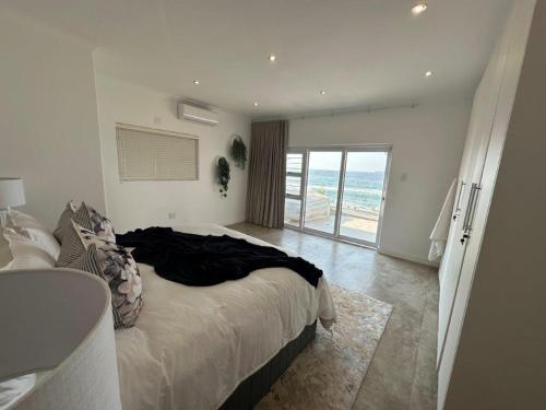 a bedroom with a bed and a view of the ocean at Summer Sunset Villa in Umdloti