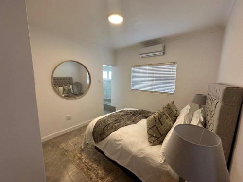 a bedroom with a bed and a mirror at Summer Sunset Villa in Umdloti