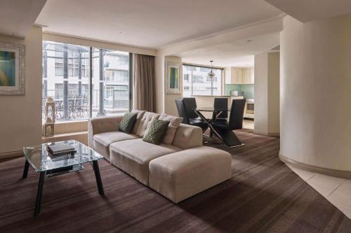 a living room with a couch and a table at Rydges World Square in Sydney