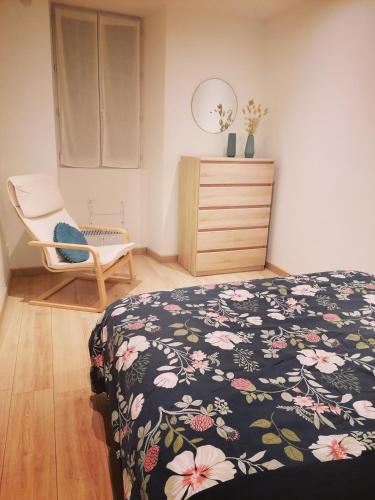 - une chambre avec un lit, une chaise et une commode dans l'établissement Charme saint Jean, à Pithiviers