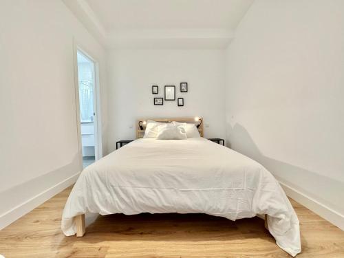 a white bedroom with a bed with white sheets at Sunny Seas Hideaway Apartment in Los Abrigos