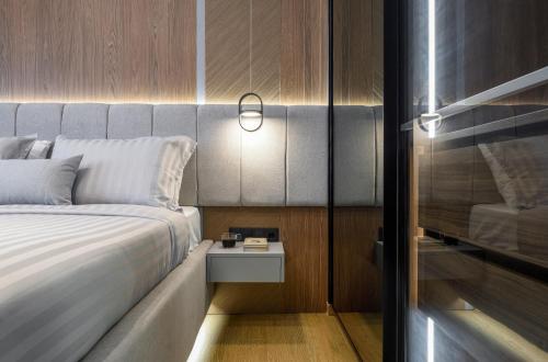 a bedroom with a bed and a side table with a lamp at Aristotelian Virtues - Tharros in Thessaloniki