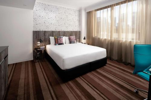 a bedroom with a large white bed and a window at Rydges Sydney Central in Sydney