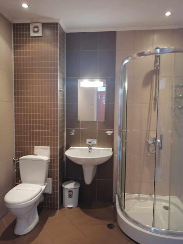 a bathroom with a toilet and a sink and a shower at St. George Guest House in Sveti Vlas