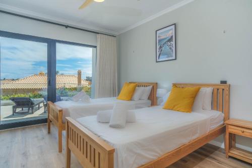 a bedroom with two beds and a large window at Casa Talay 4 Bedroom Pool Villa - Meia Praia Beach, Lagos in Lagos