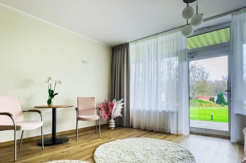 a living room with a table and chairs and a large window at WHITE HOUSE in Jastrzębia Góra