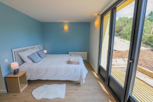 une chambre avec un lit et une grande fenêtre dans l'établissement Magnifique maison moderne avec accès direct à la mer, à Varaville