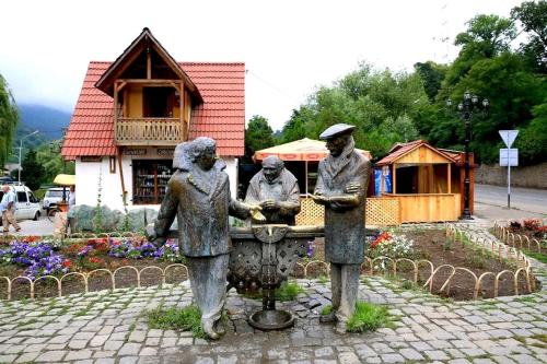 a statue of three people standing in a fountain at RiverSide Guest House in Dilijan
