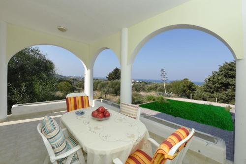 un patio con mesa y sillas con vistas en Villa Paradeisi en Paradisi