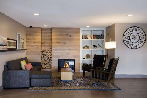 a living room with a fireplace and a clock on the wall at Country Inn & Suites by Radisson, Marion, IL in Marion
