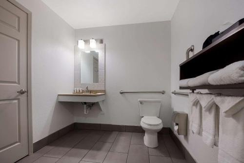 a white bathroom with a toilet and a sink at Country Inn & Suites by Radisson, Marion, IL in Marion