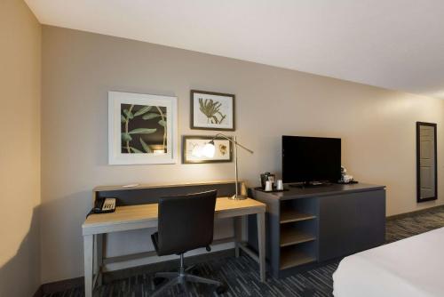 a room with a desk with a computer and a monitor at Country Inn & Suites by Radisson, Marion, IL in Marion