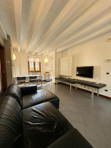 a living room with a leather couch and a flat screen tv at Alex's lake house in Riva di Solto