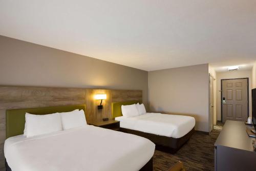 a hotel room with two beds and a desk at Country Inn & Suites by Radisson, Marion, IL in Marion