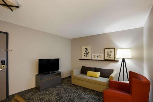 a living room with a couch and a tv at Country Inn & Suites by Radisson, Marion, IL in Marion