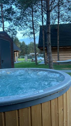 a hot tub with blue water in a backyard at Ośrodek u Polaka-domek góralski in Radkowice