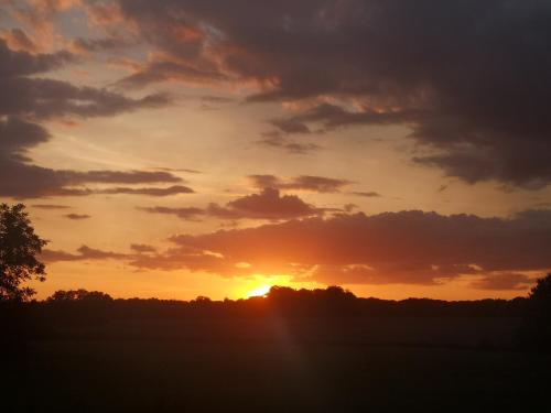 a sunset with the sun setting in the sky at le bonheur est dans le prè in Sauvigney-lès-Pesmes