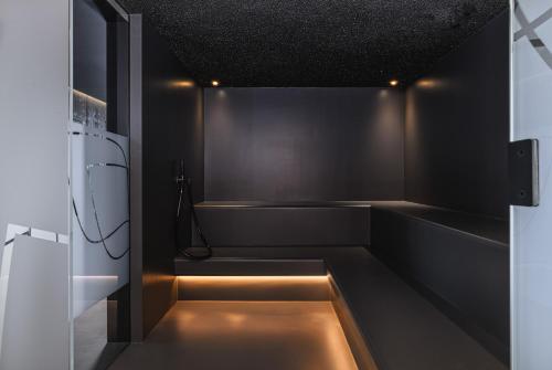 a black kitchen with a sink and a refrigerator at Romantik Hotel Schweizerhof & Spa Flims in Flims