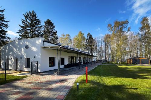 a large white building with a grass field and trees at WHITE HOUSE in Jastrzębia Góra