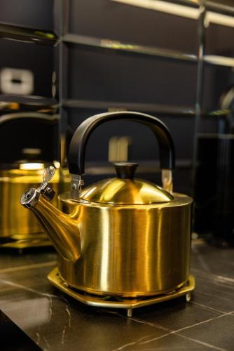 a golden tea kettle sitting on a counter at Apartament LUNA z jacuzzi Premium na Mazurach in Ełk