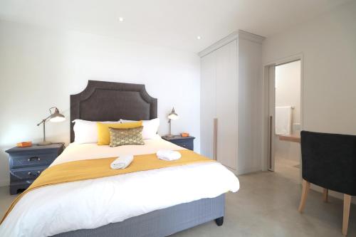 a bedroom with a large bed with two towels on it at Kestrel Apartments in Paternoster