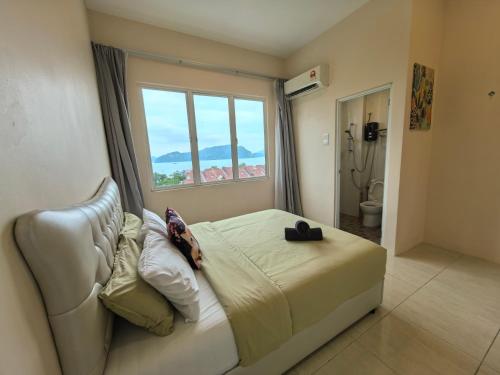 a bedroom with a bed and a large window at Langkawi Simfoni Platinum Suite in Kuah