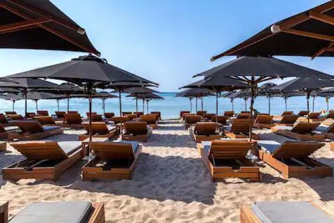 a bunch of chairs and umbrellas on a beach at RoofTop Sea View Cabin in Vari