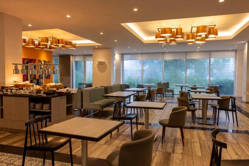 a restaurant with tables and chairs and a bar at Park Inn By Radisson Iloilo in Iloilo City