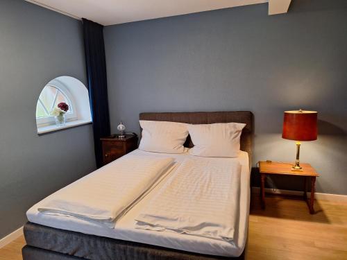 a bedroom with a bed and a table with a lamp at Bleckmanns Hof in Werne an der Lippe