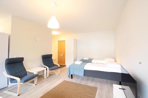 a hospital room with a bed and two chairs at Forenom Serviced Apartments Hämeenlinna Katuma 8 in Hämeenlinna