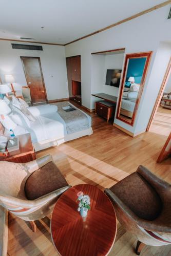 a large bedroom with a bed and a table and chairs at The Peninsula Chittagong Limited in Chittagong