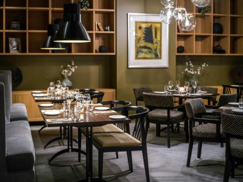 a dining room with tables and chairs and chandeliers at Quality Hotel Sarpsborg in Sarpsborg