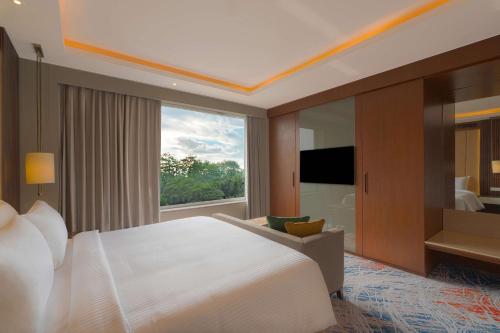 a bedroom with a large bed and a large window at Park Inn by Radisson Ayodhya in Ayodhya