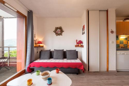 une petite chambre avec un lit et un balcon dans l'établissement Le Nid des Marmottes - Appt proche station de ski, à Villarembert