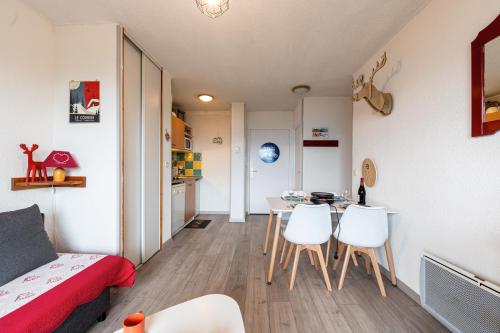 Cette petite chambre comprend une table et des chaises blanches. dans l'établissement Le Nid des Marmottes - Appt proche station de ski, à Villarembert