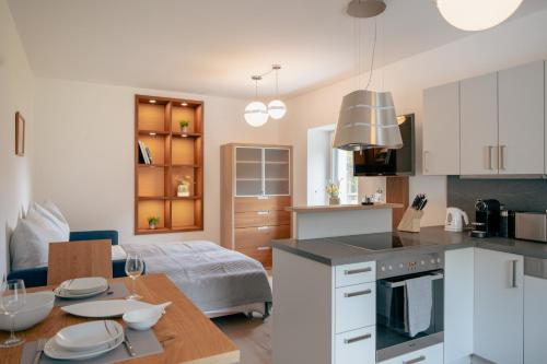 a kitchen and living room with a table and a couch at Alte Fischerei - Apartments am See in Scharfling