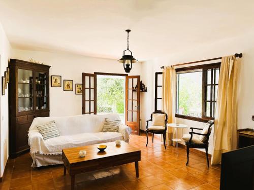a living room with a white couch and a table at Marina - Casa de campo cerca de Ciutadella in Cala Blanca