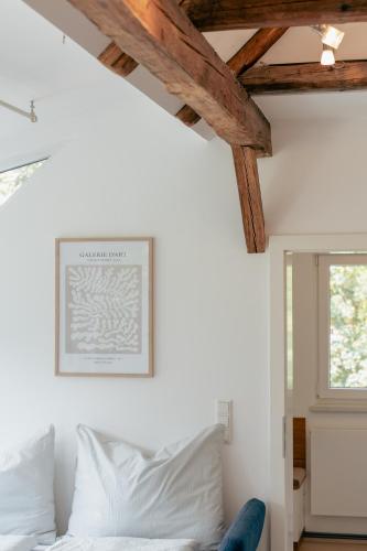 a bedroom with a white bed and a window at Alte Fischerei - Apartments am See in Scharfling