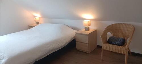 a bedroom with a bed and a chair and two lamps at Chez Jo in Villard-de-Lans