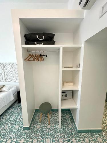 a small white closet with a stool in a room at Vesuvio View in Vico Equense