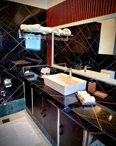 a bathroom with a sink and a black marble counter at Victorian Elegance Luxury Stays in Amritsar