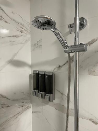 a shower head in a bathroom with white marble at Vacaciones en familia Ap Portitxol en Xàbia in Platja de l'Arenal
