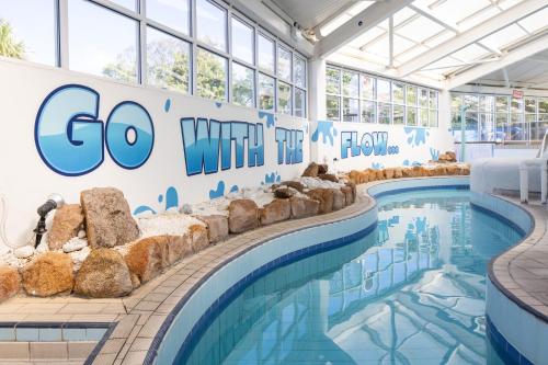 a swimming pool with a sign that says go with the flow at Merton Hotel in St. Saviour