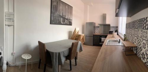 アルマンティエールにあるLa Léonce, superbe appartement plein centreのテーブルとキッチンのあるリビングルーム