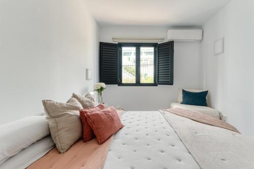 een witte slaapkamer met een bed en een raam bij Casa Tabera - Sun Club Playa del Águila in Playa del Aguila