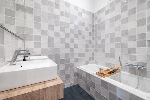a bathroom with a white sink and a tub at Soleil de la Buffa - Un joyau central à 3 min des plages in Nice