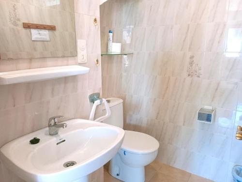 a bathroom with a white toilet and a sink at AT Chalet Stella con Piscina Privada in Peniscola