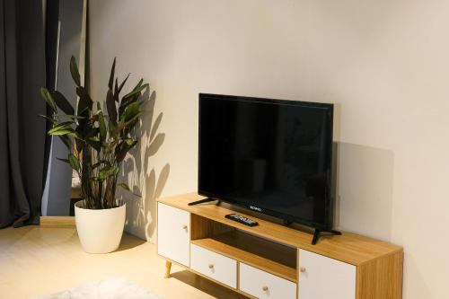 a flat screen tv sitting on top of a wooden entertainment center at Siesta Spaces Adela in Manila