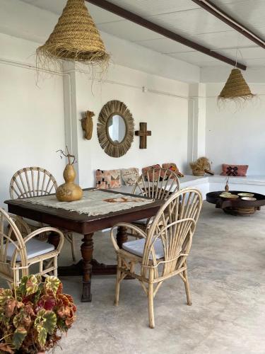 a dining room with a table and chairs and a mirror at Casa Pimenta in Vidigueira