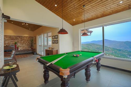 a pool table in a room with a view at SaffronStays Ridgeview Manor, Mukteshwar - 3BHK Villa with Himalayan Views & Verandahs in Mukteshwar